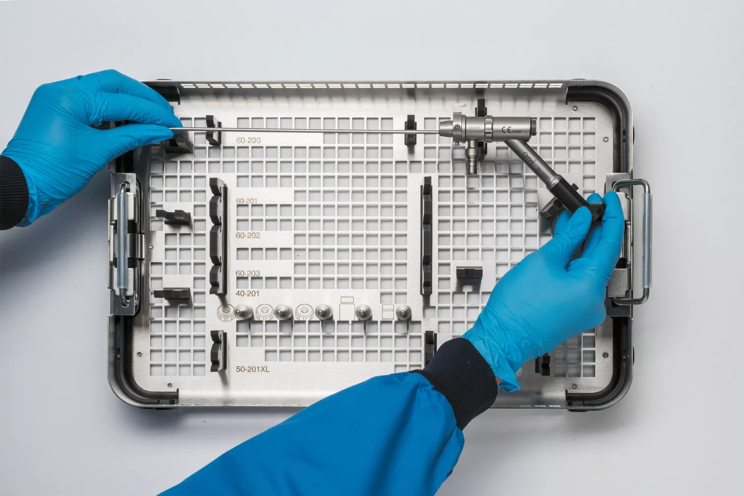 テーブルの上の医療用トレイを操作している手袋をはめた手。