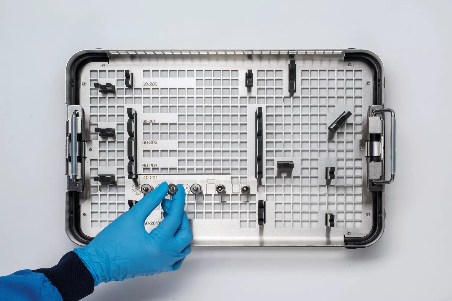 テーブルの上の医療用トレイを操作している手袋をはめた手。