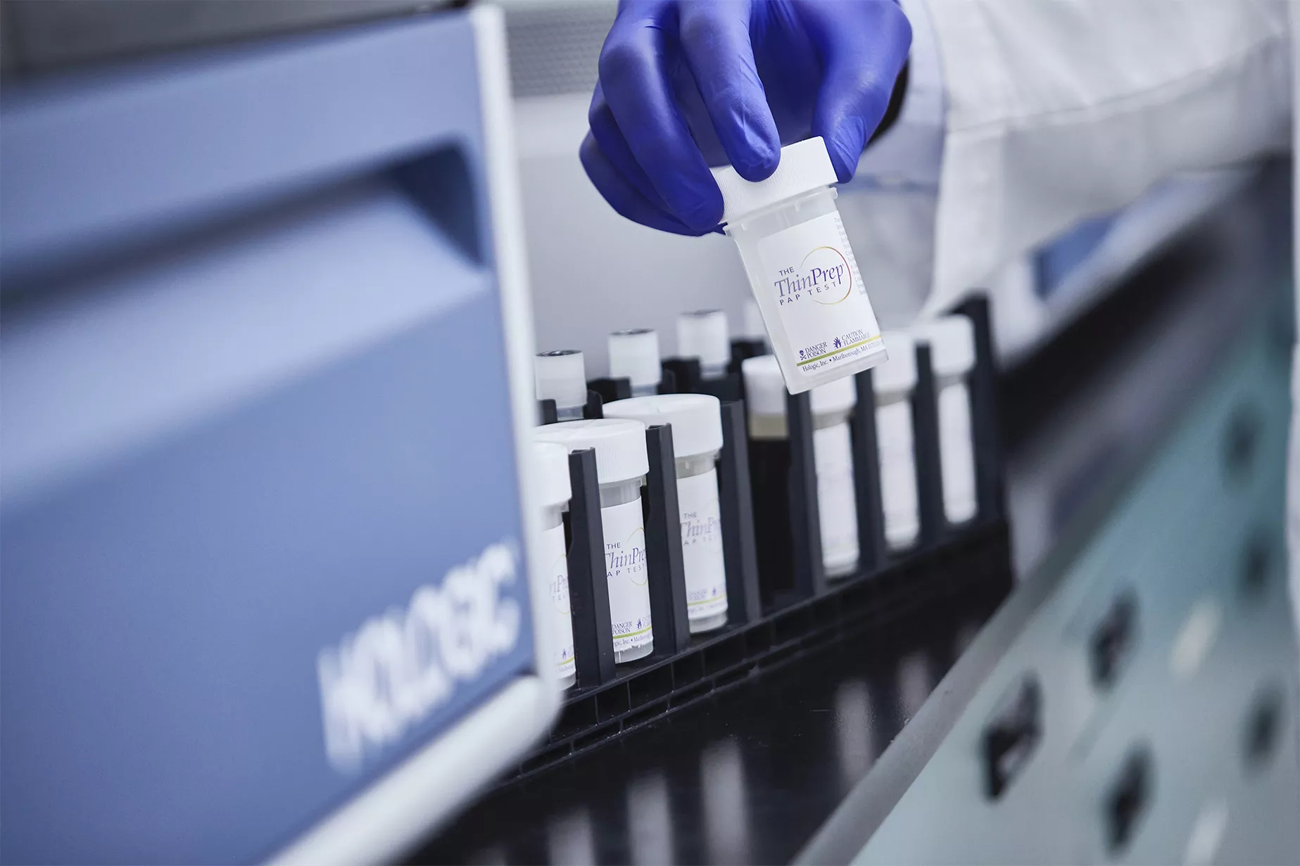 バイアルを持っている手袋をした手